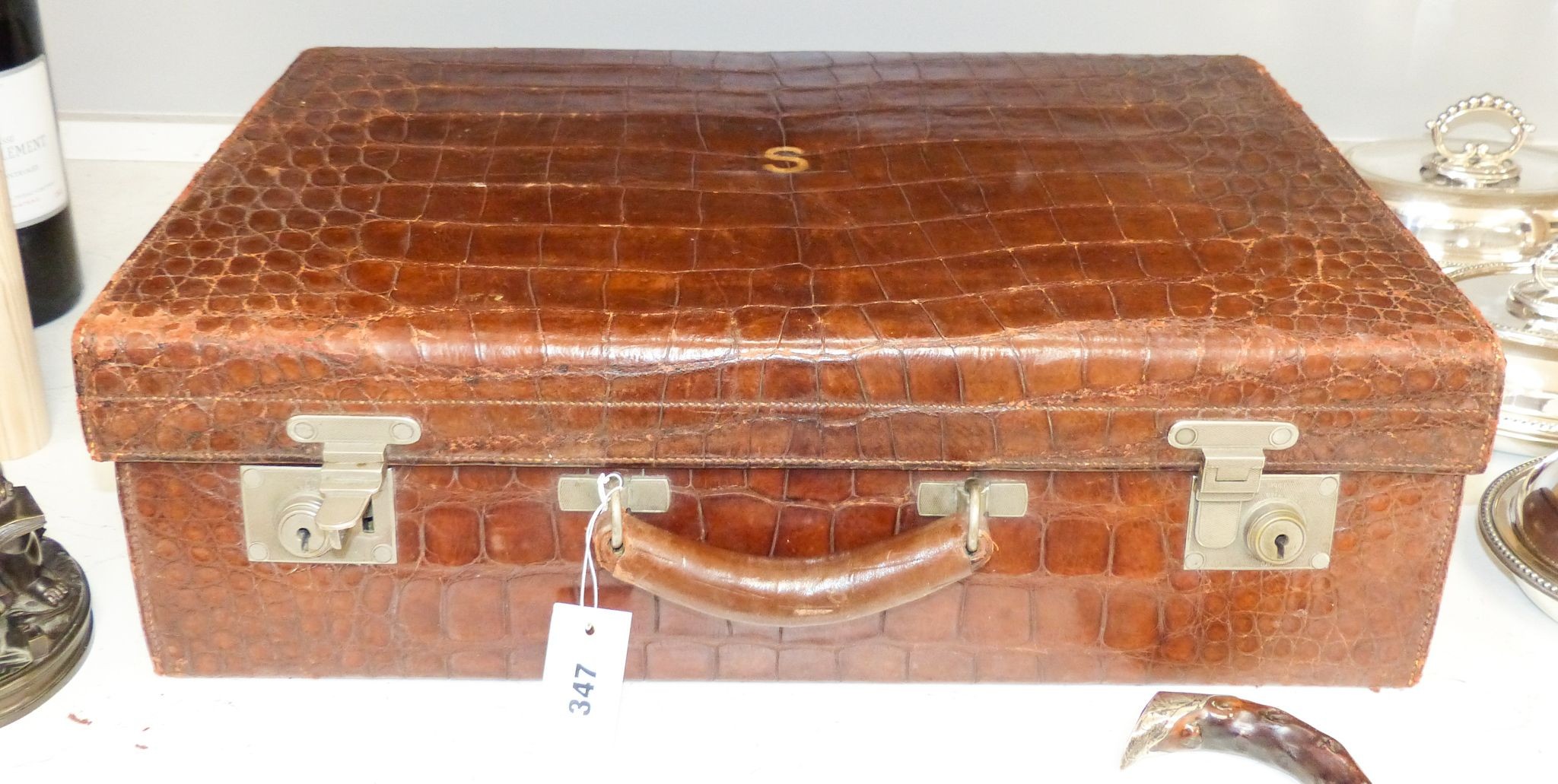 An early 20th century crocodile skin suitcase with blue leather lined interior 61cm